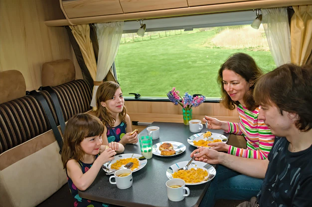 family-eating-together-rv-interior-parents-kids-travel-motorhome-camper-caravan_146539-2697